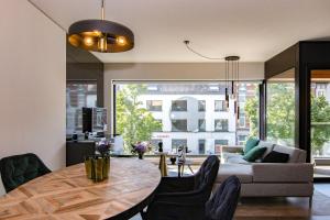 een woonkamer met een tafel en een bank bij Boulevard Botanie city apartment with parking in Hasselt