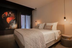 una camera da letto con un letto grande con un dipinto sul muro di Boulevard Botanie city apartment with parking a Hasselt