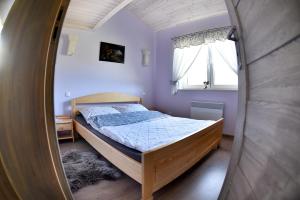 a small bedroom with a bed and a mirror at Domek letniskowy Nad Stawem in Lipusz