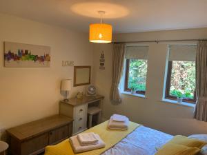 a bedroom with a bed and a desk and windows at Minster View Apartment at Talbot Court, York in York