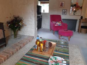 una sala de estar con una mesa con botellas. en Huberts, West End Farm, Fosse Lane, Poolbridge Road, Blackford, Wedmore en Wedmore