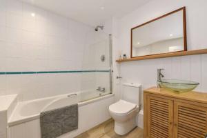 a bathroom with a toilet and a sink and a tub at The Little House, boutique home near the sea in Chichester