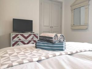 a bedroom with a bed with two towels on it at The Little House, boutique home near the sea in Chichester +12 photos