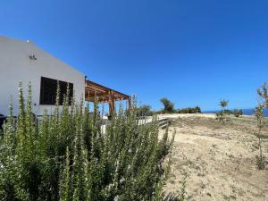 a house on a beach with the ocean in the background at David in Cefalù