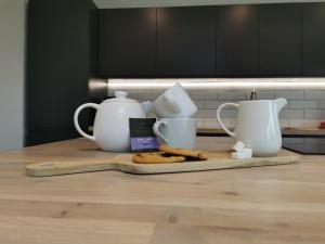 a kitchen counter with tea pots and cookies on a cutting board at Iona 4 bed luxury in the heart of Bracklesham Bay in Chichester