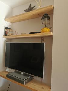 a flat screen tv sitting on a wooden shelf at Iona 4 bed luxury in the heart of Bracklesham Bay in Chichester