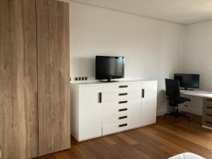 ein Zimmer mit einem weißen Schrank mit einem TV darauf in der Unterkunft Sis Pobles Bed&Breakfast in La Senia