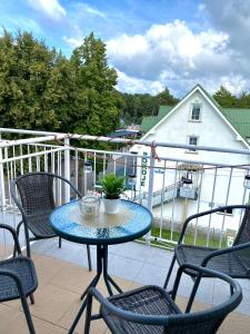 a table and chairs on a balcony with a house at Apartament Brisa in Pobierowo