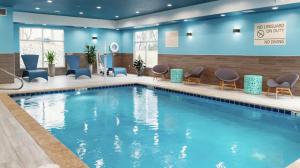 uma grande piscina num quarto de hotel com cadeiras em Hampton Inn Old Bridge NJ 