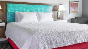 um quarto com uma grande cama branca e um tapete vermelho em Hampton Inn Old Bridge NJ 