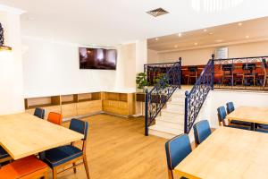 a dining room with tables and chairs and a staircase at Dona Amélia Hotel by RIDAN Hotels in Fátima