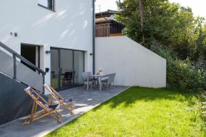 um pátio com cadeiras e uma mesa num quintal em Apartment Steixner em Westendorf