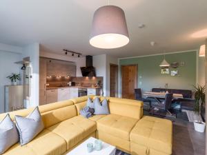 a living room with a yellow couch and a kitchen at Apartment Steixner in Westendorf