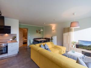 uma sala de estar com um sofá amarelo e uma cozinha em Apartment Steixner em Westendorf