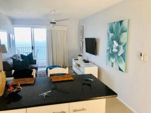 a living room with a kitchen and a living room with a couch at Sands Beach Breaks Umdloti Beach View in Umdloti +47 photos