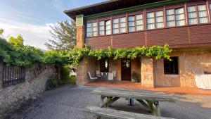 a wooden bench sitting in front of a building at Hotel Rural Cuadroveña in Arriondas