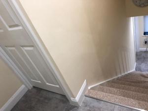 eine Treppe mit einer weißen Wand und einer Tür in der Unterkunft CuteRooms in Cheltenham