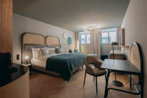 巴塞尔Hotel Märthof Basel的一间卧室，配有一张床、一张桌子和一把椅子