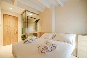 a bedroom with a white bed with towels on it at BAYIT Charming Place in Polignano a Mare