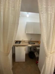 a kitchen with a sink and a table with a curtain at Masseria Montanari in Carpignano Salentino +76 photos