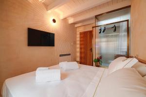 a bedroom with two white beds and a television at BAYIT Charming Place in Polignano a Mare
