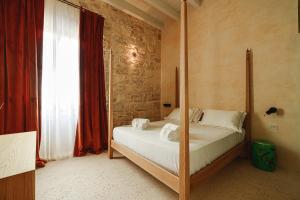 a bedroom with a bed with a four poster bed at BAYIT Charming Place in Polignano a Mare