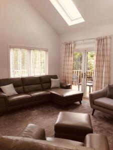 a living room with a brown couch and chairs at Linne Lodge in Tain