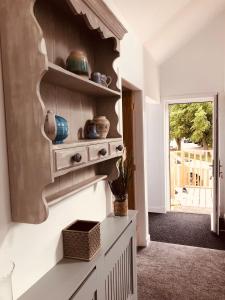 a room with a shelf with bowls on the wall at Linne Lodge in Tain