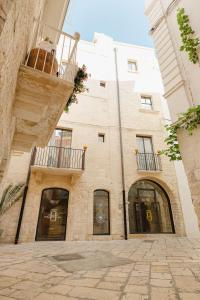 a brick building with two windows and a balcony at BAYIT Charming Place in Polignano a Mare