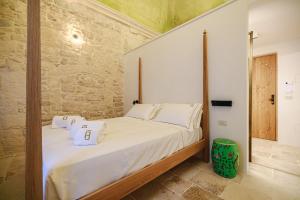 a bedroom with a bed with white sheets and pillows at BAYIT Charming Place in Polignano a Mare