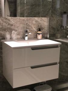 une salle de bain avec un lavabo blanc et un miroir dans l'établissement Centrum, à Subotica