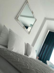 a mirror sitting on top of a bed with pillows at Centrum in Subotica