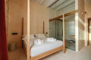 a bedroom with a bed with a glass wall at BAYIT Charming Place in Polignano a Mare