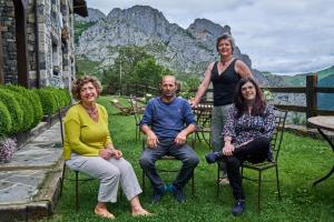 a group of people sitting in chairs in the grass at La Posada de Cucayo in Dobres