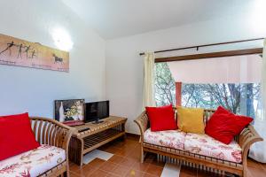 Televízia a/alebo spoločenská miestnosť v ubytovaní Villa i Ginepri Villasimius località Porto sa ruxi