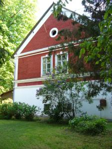Casa roja y blanca con ventana en Kalmár Vendégház-Vadászház, en Tornyiszentmiklós