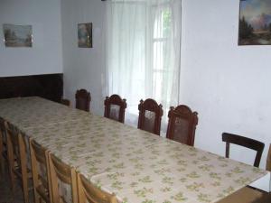 d'une salle à manger avec une table, des chaises et une fenêtre. dans l'établissement Kalmár Vendégház-Vadászház, à Tornyiszentmiklós