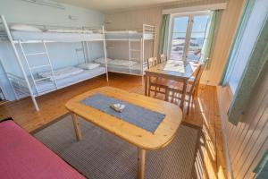 Zimmer mit Etagenbetten, einem Tisch und einem Schreibtisch in der Unterkunft Lofoten Å HI hostel in Å