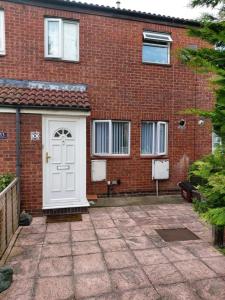 a brick building with a white door in front of it at Heronsgate GH008 in Thamesmead