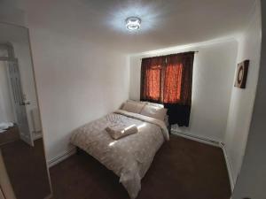 ein kleines Schlafzimmer mit einem Bett und einem Fenster in der Unterkunft Heronsgate GH008 in Thamesmead