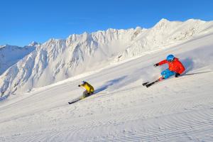 two people skiing down a snow covered mountain at Mountain alpine in Kappl