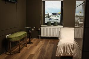 a bedroom with a bed and a window with a boat at Heeren aan de Haven in Streefkerk