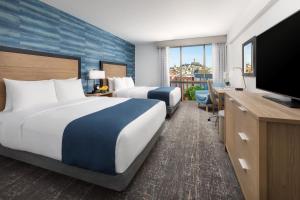 a hotel room with two beds and a flat screen tv at Hotel Caza Fisherman's Wharf in San Francisco +61 photos