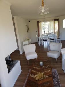 sala de estar con sillas blancas y mesa en Al Nair Casa de playa RESERVA CON SEÑA, en La Pedrera