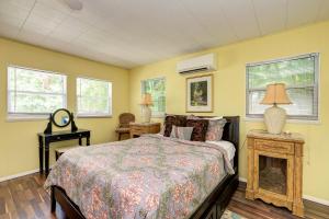 a bedroom with a bed and two lamps and windows at Cottage Haven-One Minute Walk To The Beach-Private Yards-Keyless Locks in Bradenton Beach