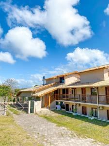 a building with a blue sky and clouds at Rosamar Suites in Praia do Rosa