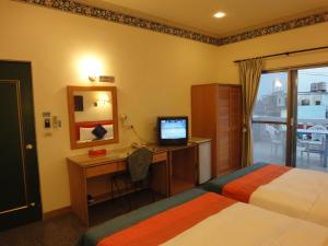 墾丁的住宿－墾丁福樂渡假旅店，酒店客房设有两张床和一张带电脑的书桌
