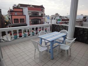 een blauwe tafel en stoelen op een balkon bij Formost Hotel in Kenting