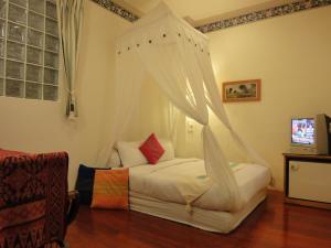 墾丁的住宿－墾丁福樂渡假旅店，一间卧室配有一张带天蓬的床