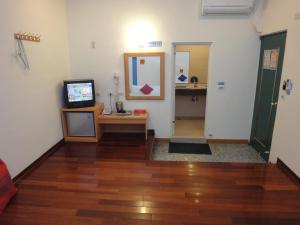 sala de estar con TV y espejo en Formost Hotel, en Kenting